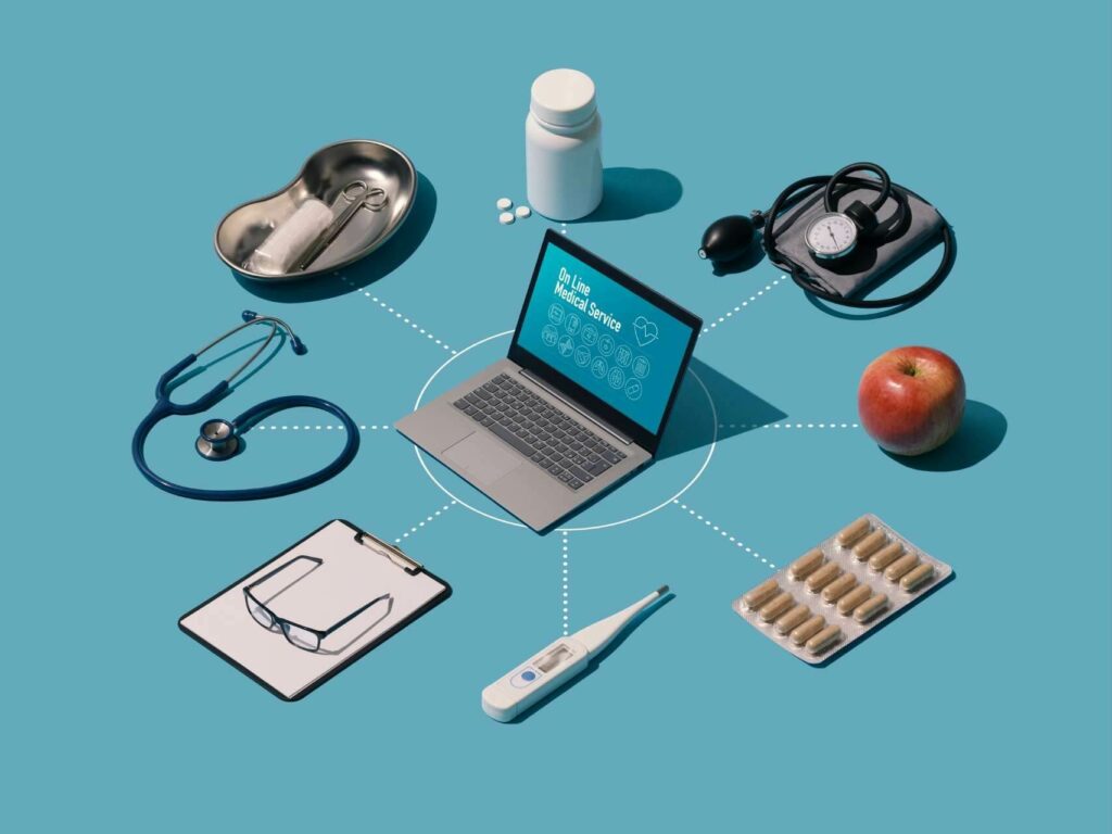 Grafika przedstawiająca laptop i kilka otaczających go atrybutów kojarzących się z ochroną zdrowia: stetoskop, ciśnieniomierz, blister z lekami, termometr i inne